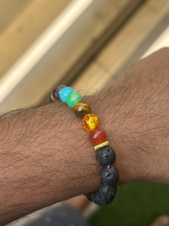 7 chakra natural bracelet with lava stones and colorful gemstones worn on arm.